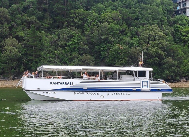 A boat named KANTARRABI on a body of water with a forested shoreline in the background. 2