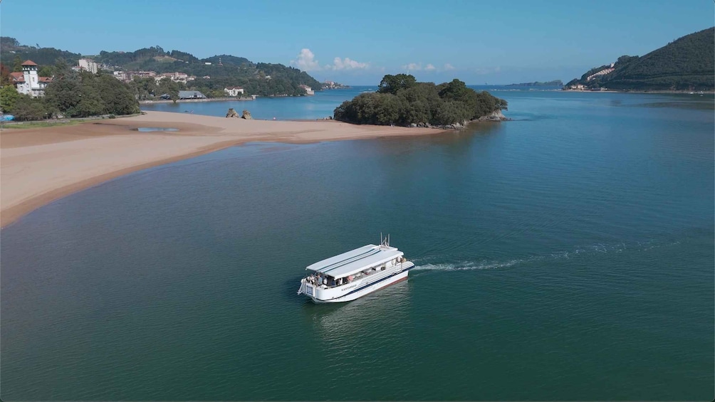 A boat on a calm lake with a sandy beach and a forested island. 3