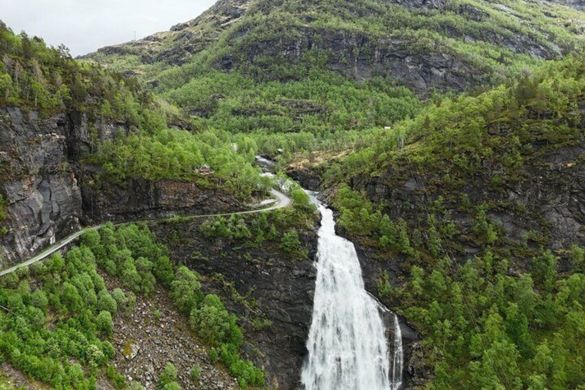 A waterfall cascading down a rocky cliff surrounded by lush greenery. 5