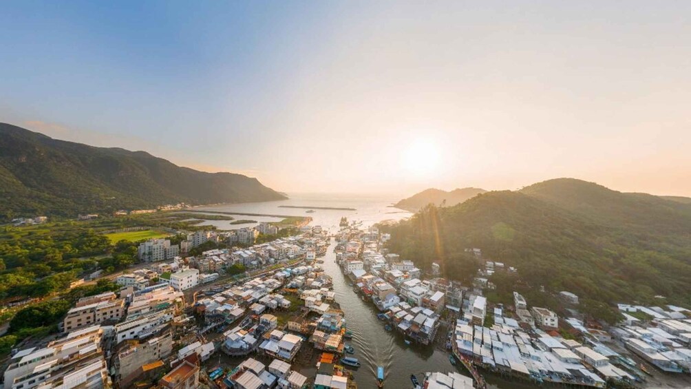 A coastal cityscape with a river running through it, surrounded by hills. 1