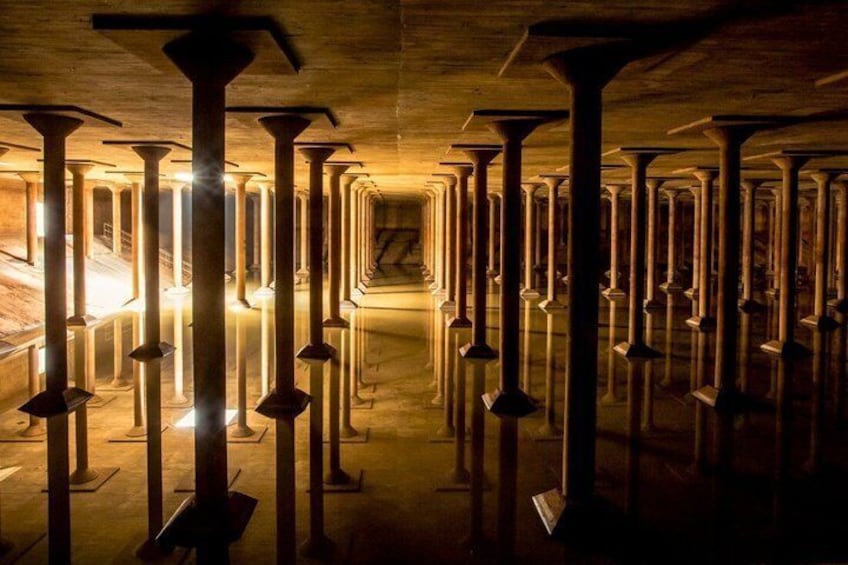 A series of tall, evenly spaced columns in a dimly lit corridor. 1