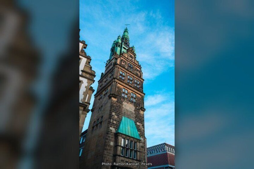 A historic building with a green roof and a clock tower. 4