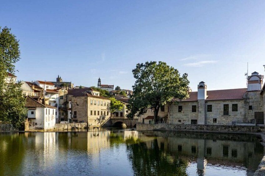 A historic town with stone buildings, a river, and a bridge. 3