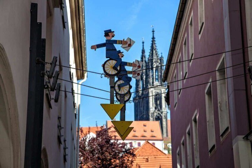A street performer balancing on a tightrope, with a church spire in the background. 4