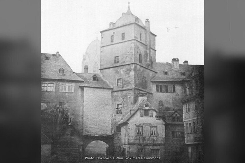 A historic building with a prominent tower and a smaller attached structure. 4