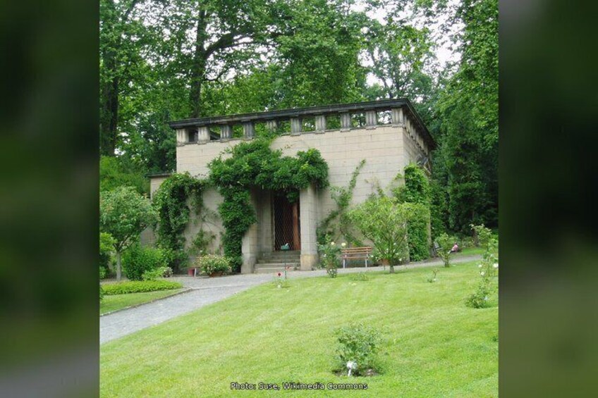 A building with a stone facade, surrounded by a well-maintained lawn and trees. 2