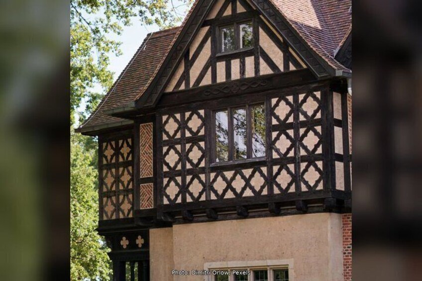 A half-timbered house with a steeply pitched roof and a brick base. 4