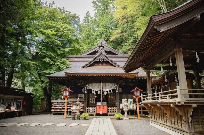 A traditional Japanese building with a tiled roof, surrounded by trees. 2