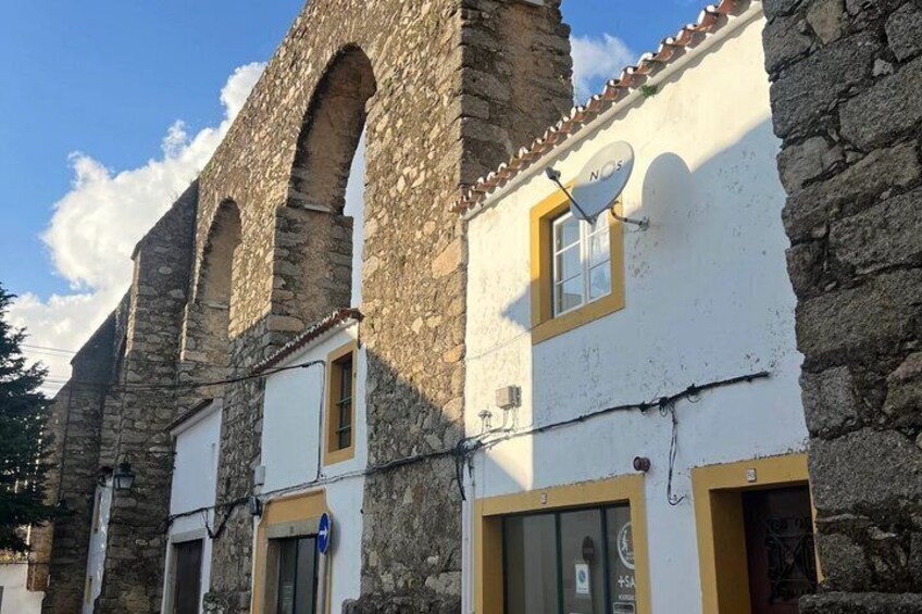 A stone building with arched windows and a white facade. 3