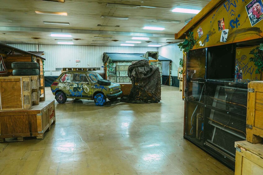 A vehicle with graffiti and a damaged front in a workshop. 2