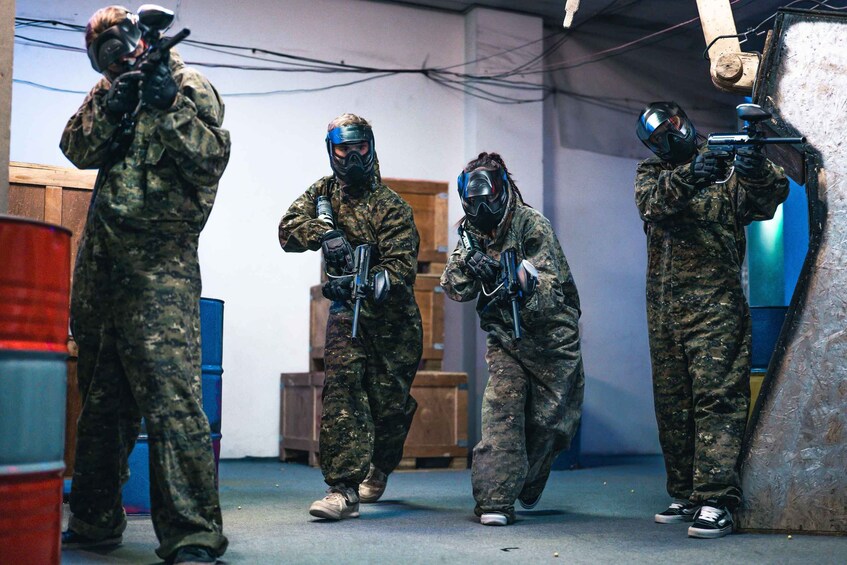 Four people in military-style paintball gear. 1