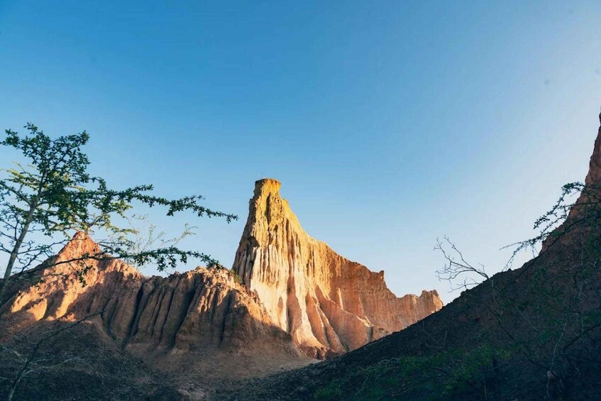 A rugged mountain landscape with a prominent, steep, conical rock formation. 3