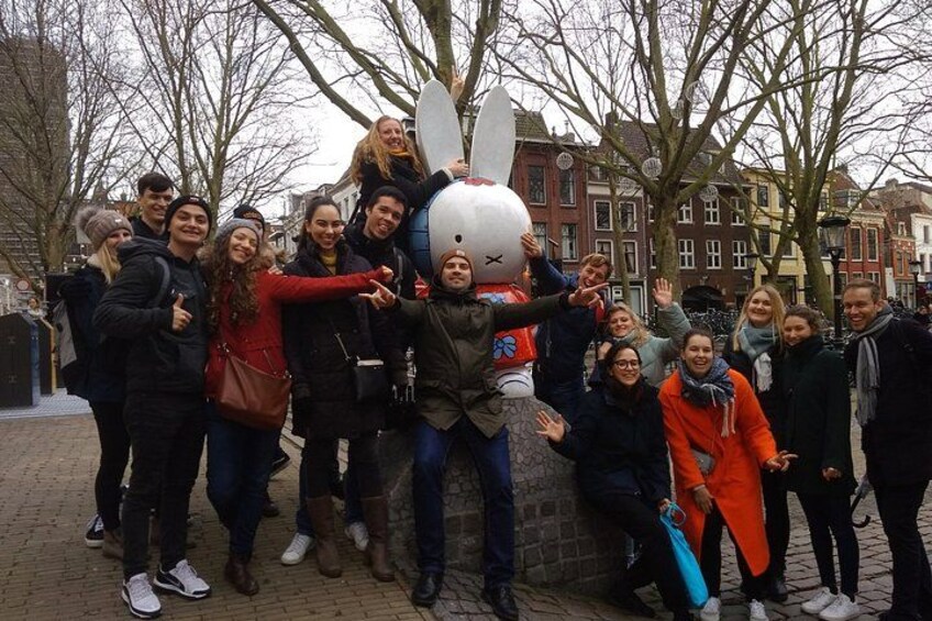 A group of people posing with a large snowman statue. 1
