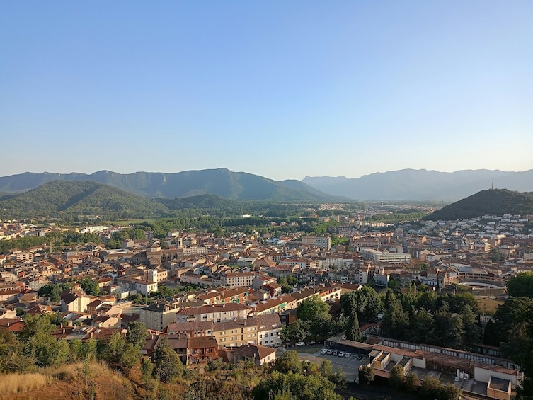 A panoramic view of a city with a mountainous backdrop. 1