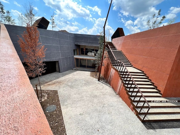 A modern architectural structure with a staircase leading up to a platform. 5