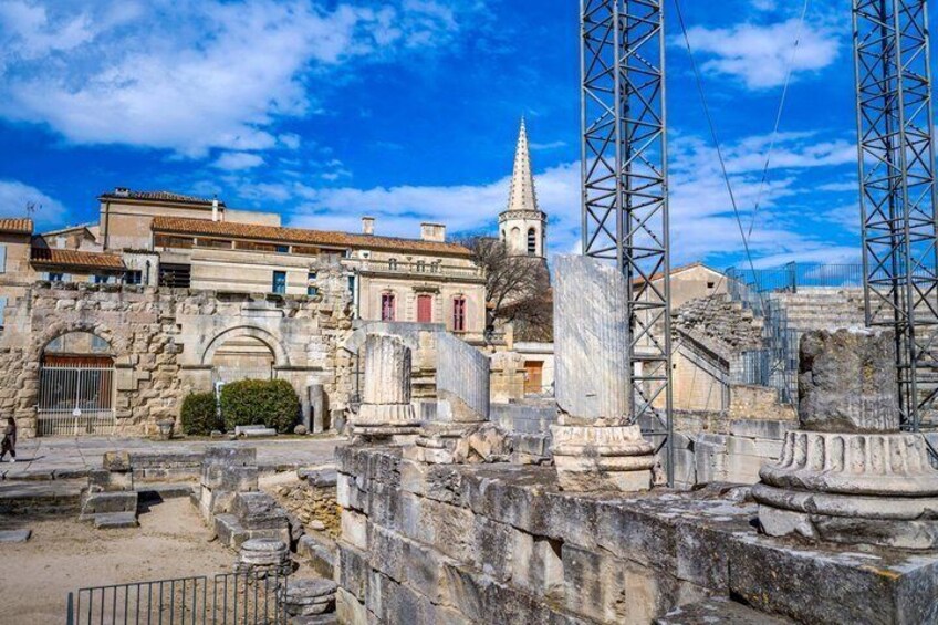 Ancient ruins with stone structures, a church, and modern construction cranes. 5