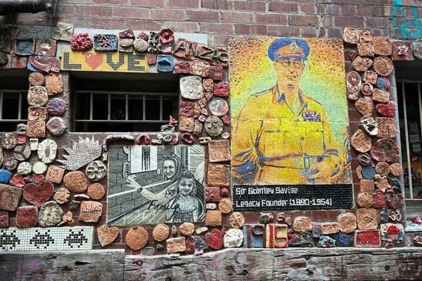 A wall decorated with various objects and a mosaic portrait. 5