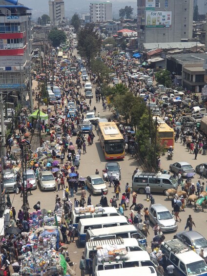 A busy urban street with numerous vehicles and pedestrians. 2