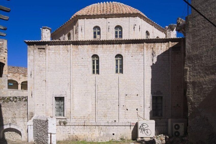 A historic building with a tiled roof, arched windows, and a stone facade. 5