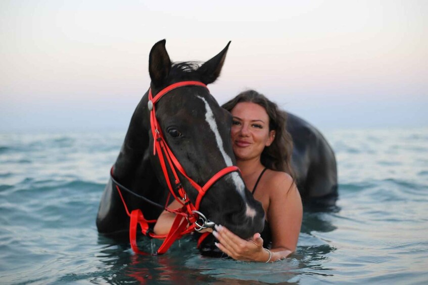 A person in water with a horse. 1