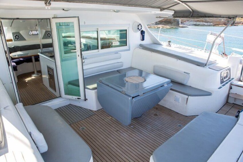 A boat's interior with a dining area, a small table, and a seating arrangement. 4
