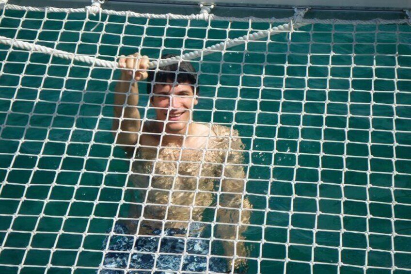 A person in a netted enclosure with a tiled floor. 2