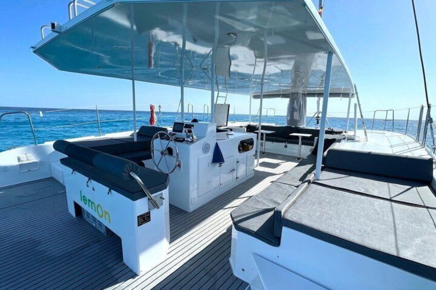 A boat deck with a covered seating area, a steering wheel, and a nameplate reading 'lemOn.' 3