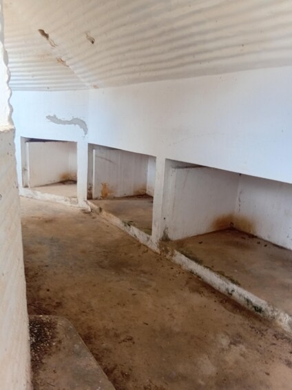 Un pasillo vacío con paredes blancas y piso de concreto. 3