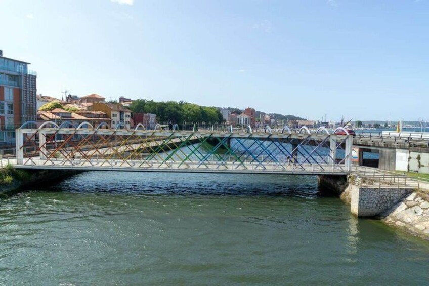 A bridge over a river with buildings in the background. 2