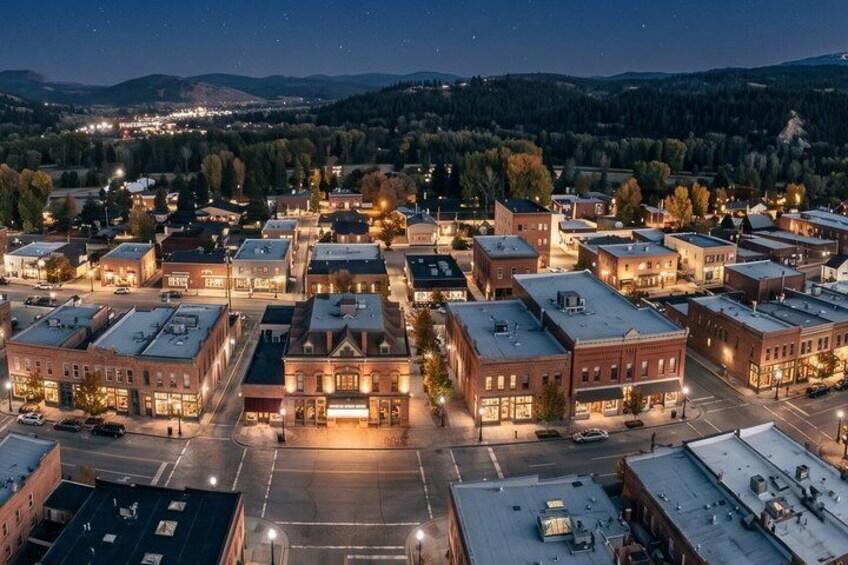 A town at night with illuminated buildings and a clear view of the surrounding hills. 5