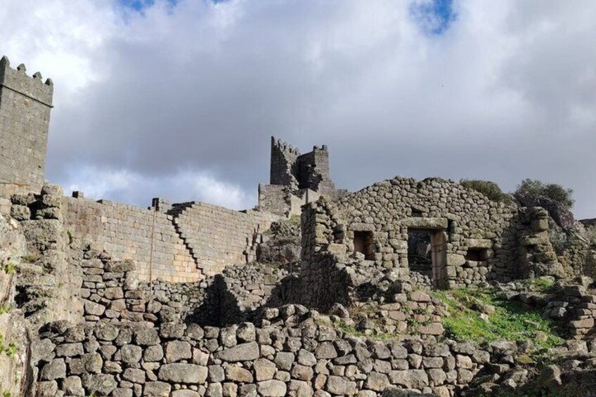 Ancient stone ruins with a castle-like structure, including walls and a tower. 4
