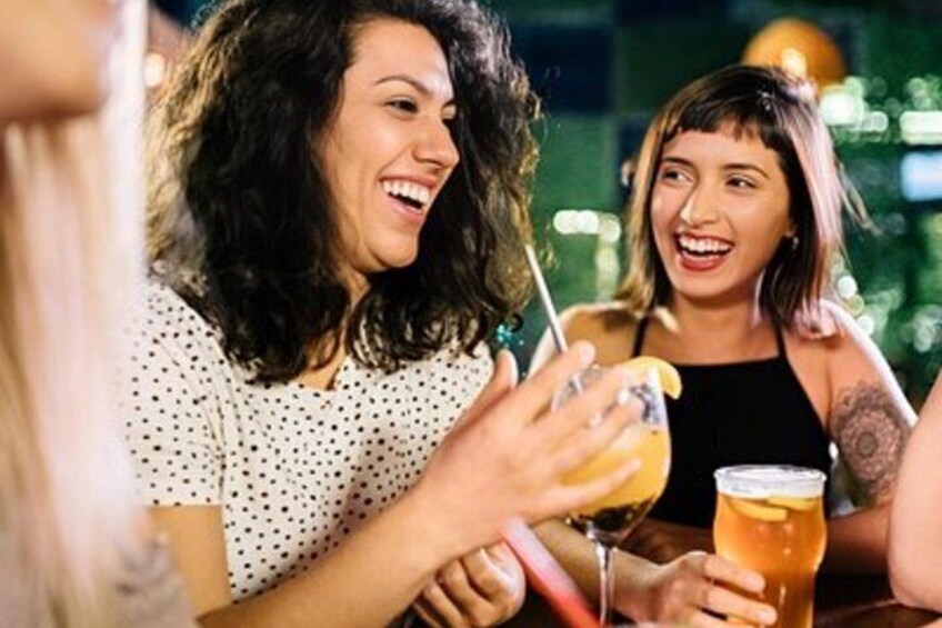 Two people holding drinks, one with a straw and one with a slice of lemon. 2