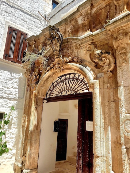 An ornate stone archway with intricate carvings and a metal gate. 5