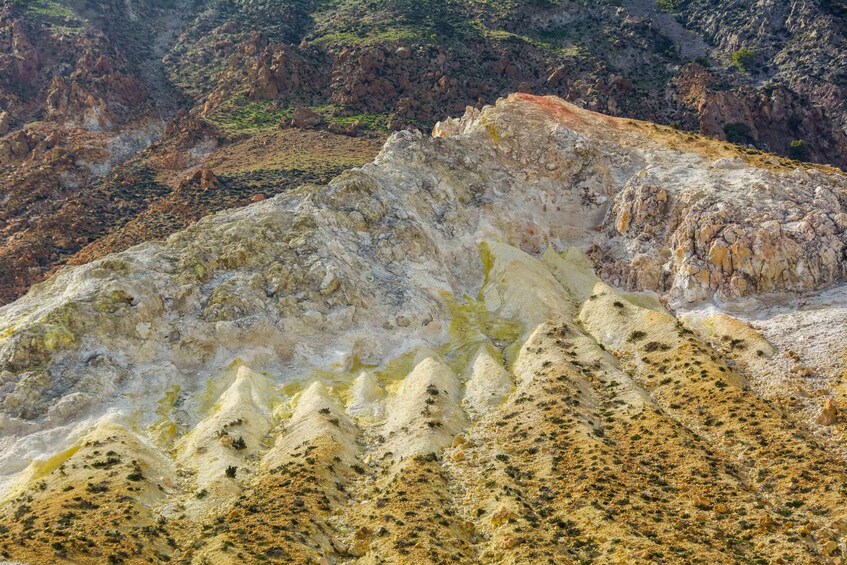 A rugged landscape with layered rock formations and sparse vegetation. 3