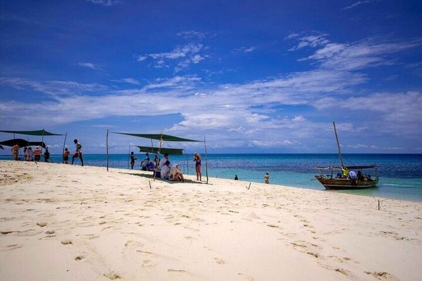 A beach with people, a boat, and a clear sky. 4