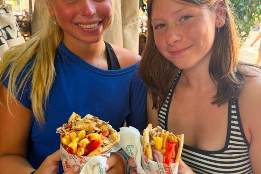 Two people holding food containers with sandwiches and fries. 4