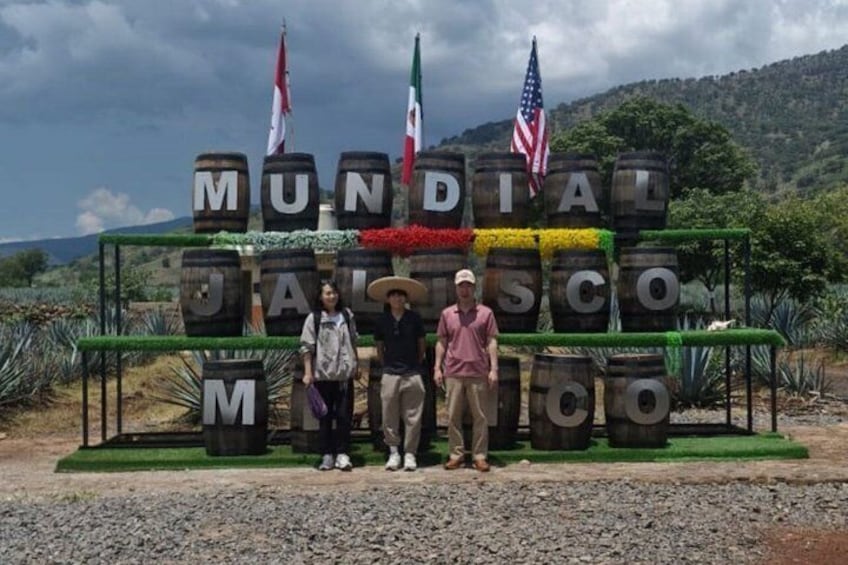 A sign with the text 'MUNDIAL JALISCO' surrounded by barrels and flags. 2