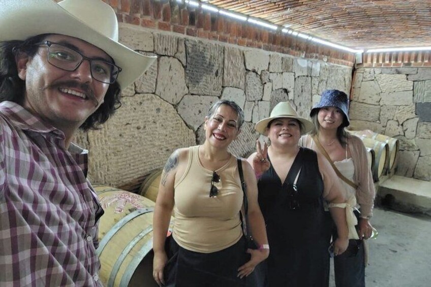 A group of people in a stone-walled cellar with barrels. 5