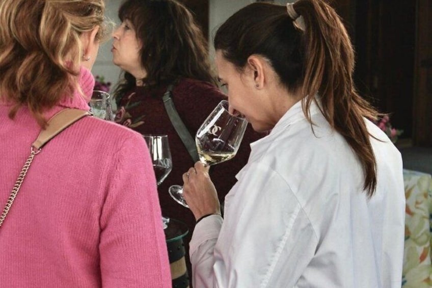 A group of people at a social gathering, some holding wine glasses. 3