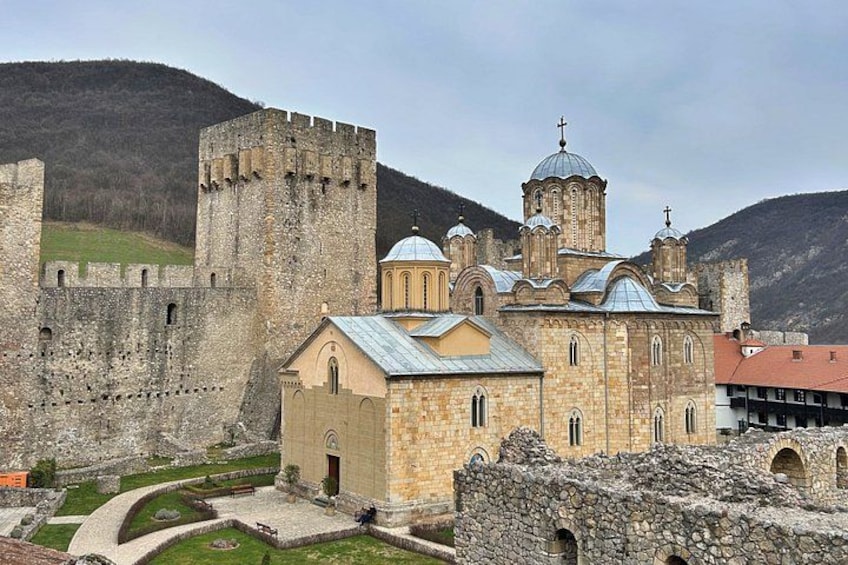 A historic stone fortress with a church featuring domed architecture and a bell tower. 1