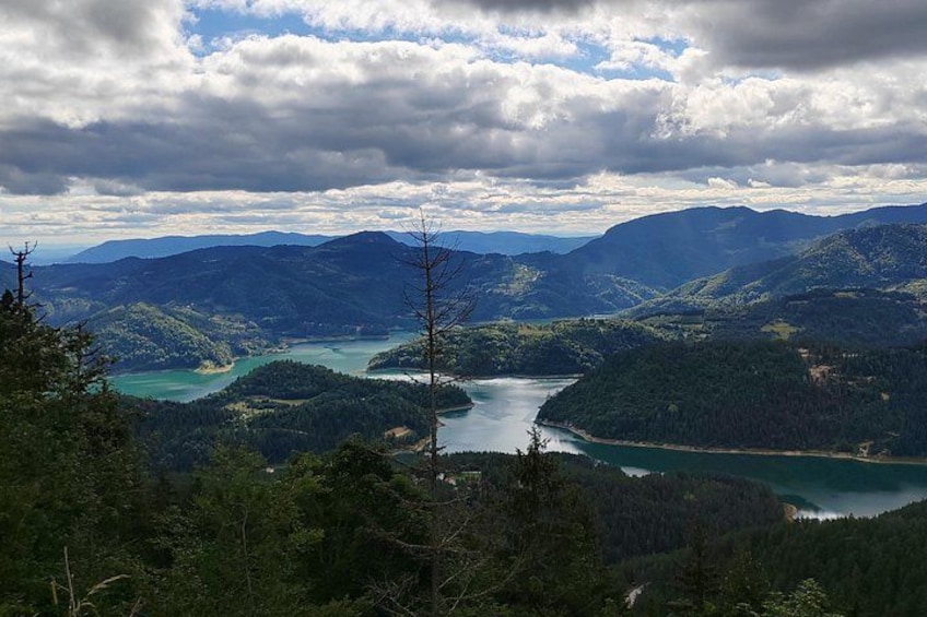 A mountainous landscape with a river winding through it, surrounded by dense forests. 3
