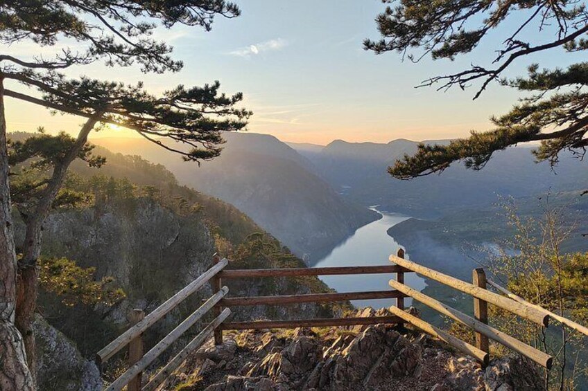 A wooden staircase leading to a viewpoint overlooking a river and mountains. 4