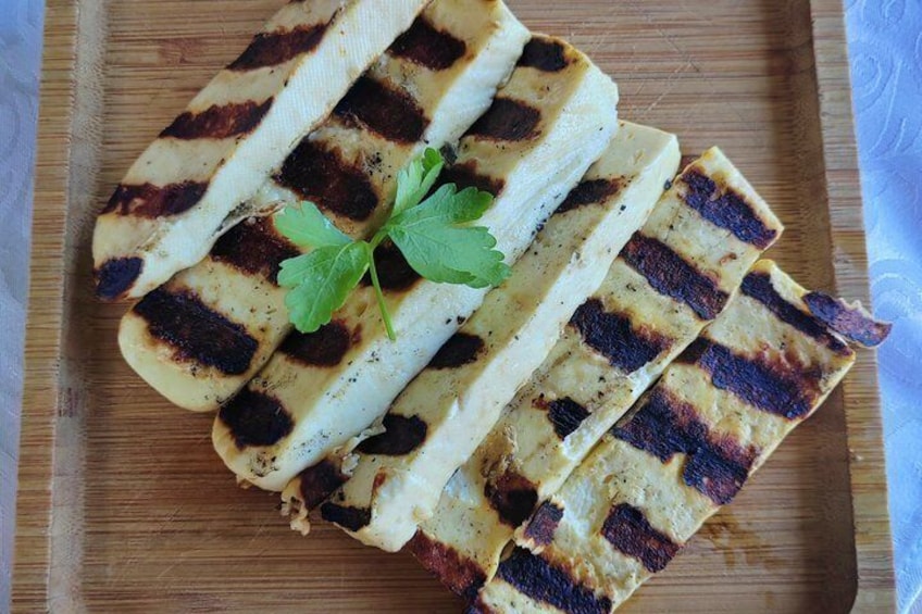 Grilled flatbread slices on a wooden cutting board with a garnish of parsley. 2