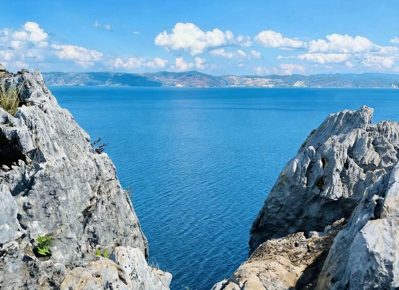A coastal landscape with rocky cliffs and a clear blue sea. 4
