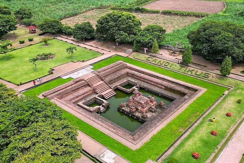 An ancient stone structure surrounded by well-maintained gardens and pathways. 3