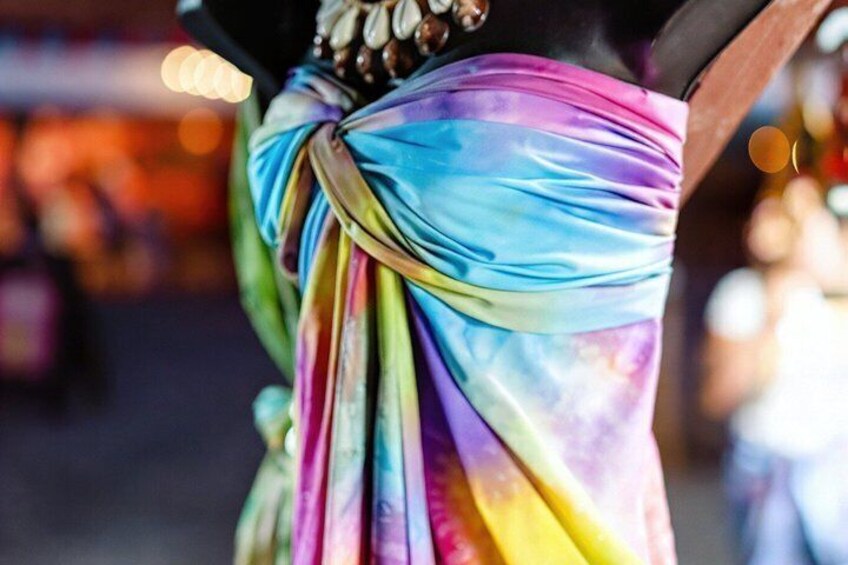 A colorful fabric draped around a person's waist. 5