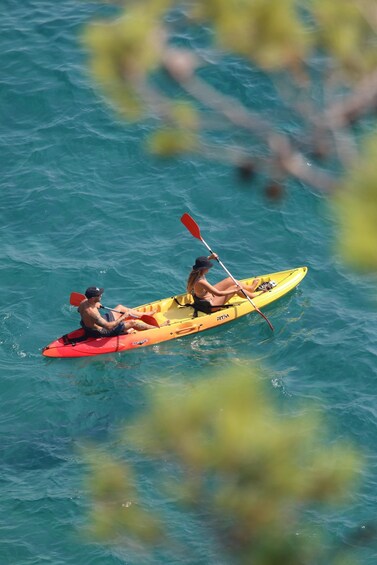 Two people kayaking on turquoise water. 1