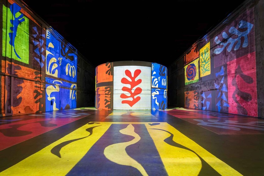 A brightly lit stage with colorful abstract patterns and a central red leaf-like design. 3