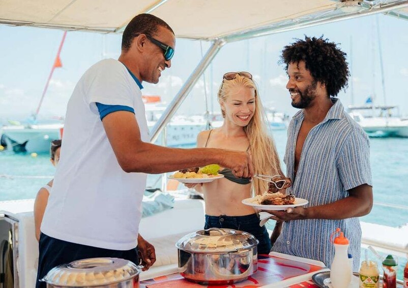 Three people on a boat, serving food from a buffet. 5