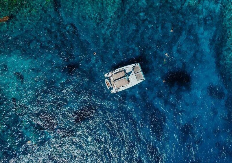 A small boat floating in clear blue waters. 3